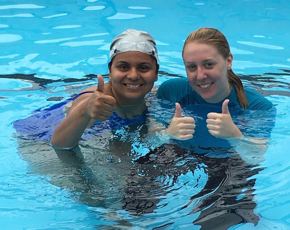 An adult swimmer smiling at the poolside