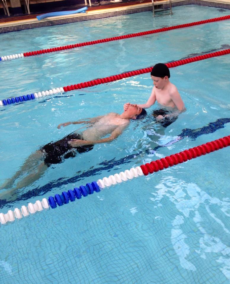 Two boys practising a rescue tow in the pool